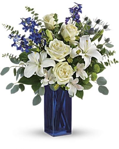 With its deep cobalt glass vase and pure white blooms, this soothing bouquet is a stylish gesture for any special occasion!
This arrangement includes white roses, white asiatic lilies, white alstroemeria, green button spray chrysanthemums, blue eryngium, bupleurum, spiral eucalyptus, silver dollar eucalyptus, and lemon leaf.