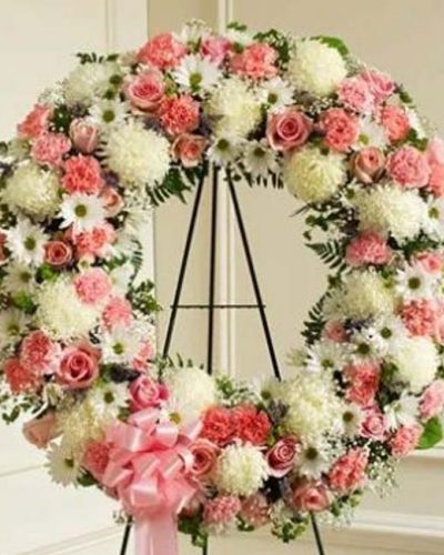 Finding the perfect expression of your care and concern during difficult times requires thoughtful consideration. This standing wreath - crafted from exquisite pink and white flowers such as roses, alstroemeria, and carnations accented by baby's breath, salal, heather and more - beautifully reflects the love and sympathy that is in your heart. Appropriate for family, friends and business associates to send directly to the funeral home.
