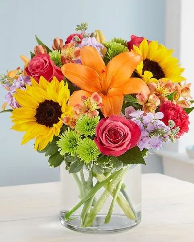 Like a warm embrace, our vibrant flower bouquet delivers your sentiments to someone special. A rich gathering of yellow and orange blooms, with pops of bright pink and purple, it's more than a gift - it's a way to express how you feel inside.